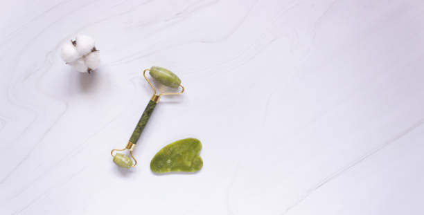 istock Gua sha roller and jade stone scraper on white background, free space for text. Chinese massage technique 1320183161