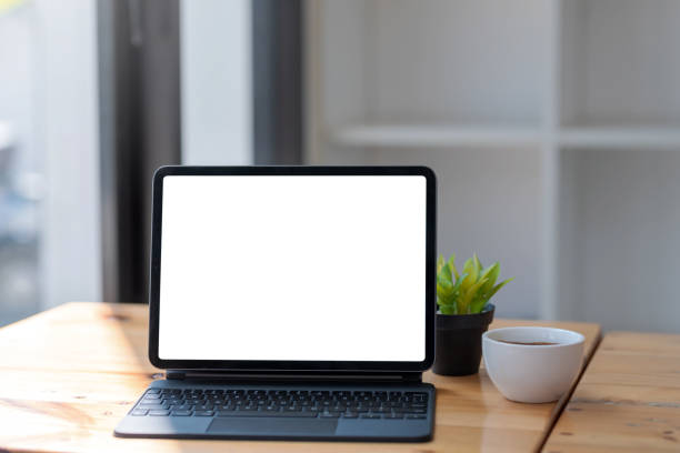 istock Mock up tablet blank screen with a coffee mug placed at the table in office. 1320185214