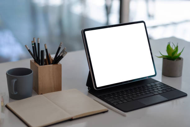 istock Digital tablet blank screen on the desk with coffee and book pencils at the office. 1320185400