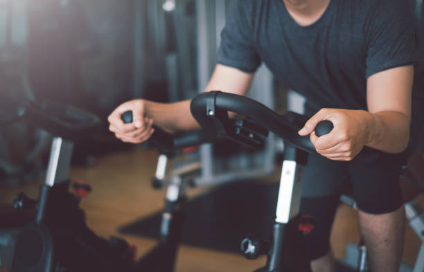 istock Man exercise bicycles at the gym 1320185403