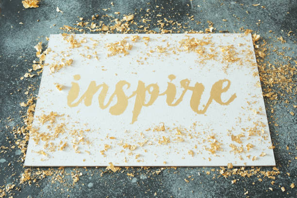 istock Inspire. Motivating lettering on white board. Handmade creativity. Gold letters. Gilding. 1320186500