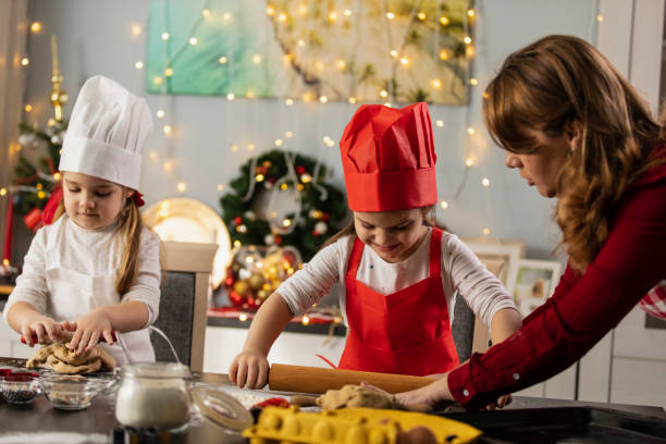 istock Two little chef's and their mother making dough for gingerbread cookies together 1320186572