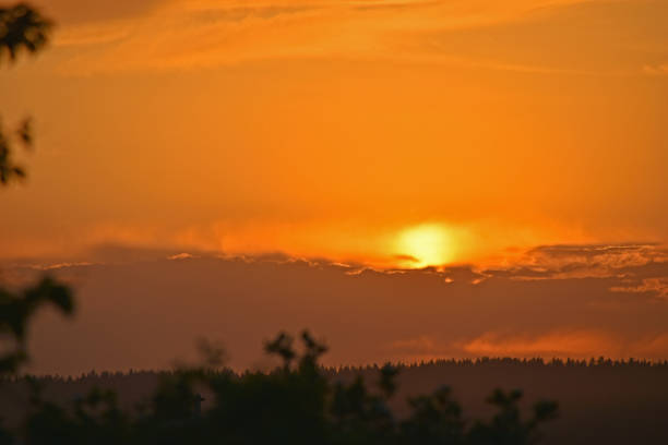 Sunset sun on the horizon with clouds in the evening