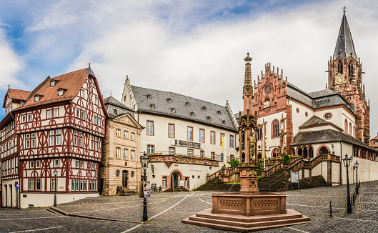View of the historic Stiftsplatz in Aschaffenburg with the Collegiate Church of St. Peter and Alexander, the Stiftsbrunnen, the Löwenapotheke and the Stiftsmuseum.