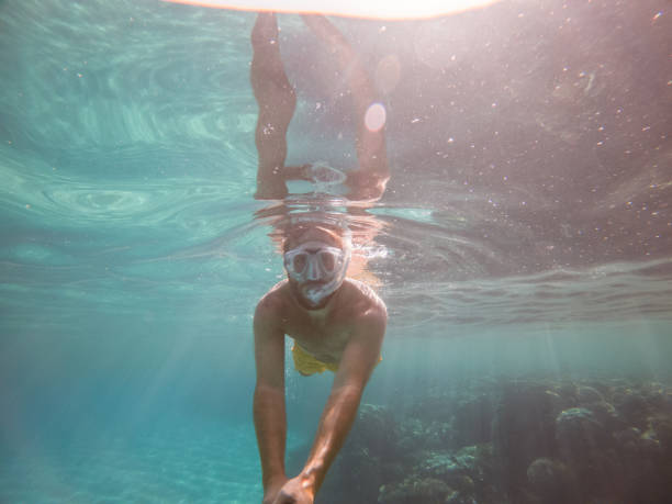 istock Man takes selfie underwater, clear blue sea 1320189082