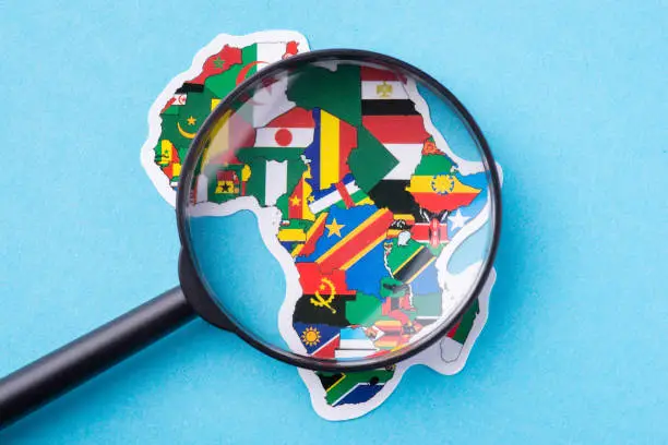 Magnifying glass pointing on Africa continent with flags of countries