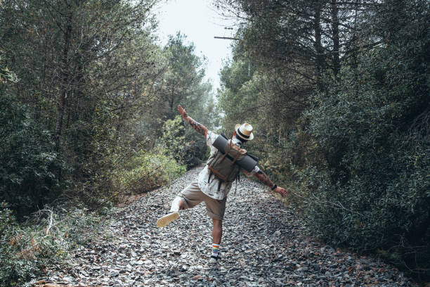 istock Happy traveler walking on an abandoned train tracks path 1320190909