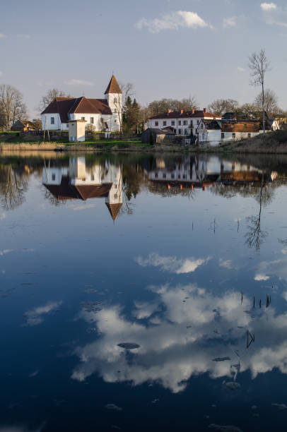 istock Alsunga catholic church and reflection in lake, Latvia 1320191586