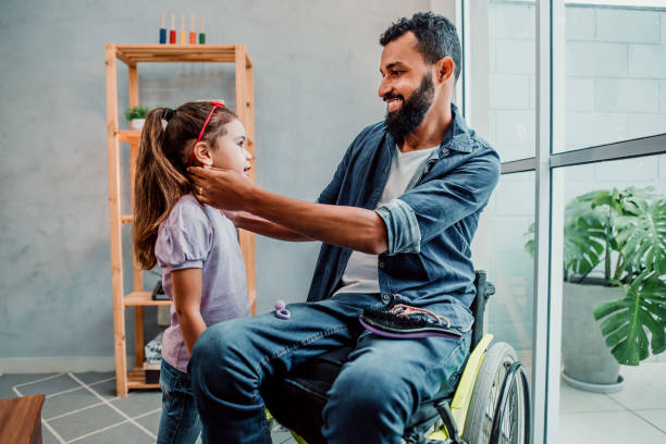istock Father in wheelchair fixing daughter's hair 1320193314
