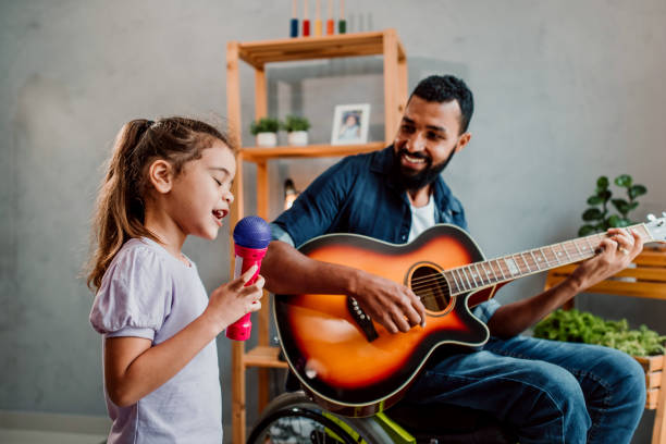 istock Father in wheelchair has fun singing with his daughter 1320193362