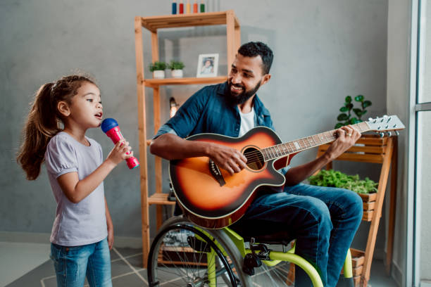 istock Father in wheelchair has fun singing with his daughter 1320193365