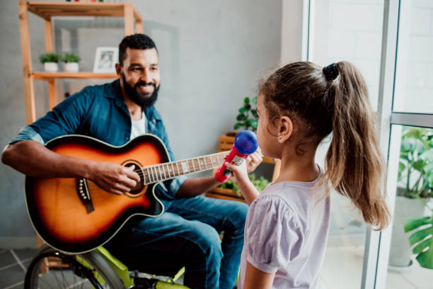 istock Father in wheelchair has fun singing with his daughter 1320193390