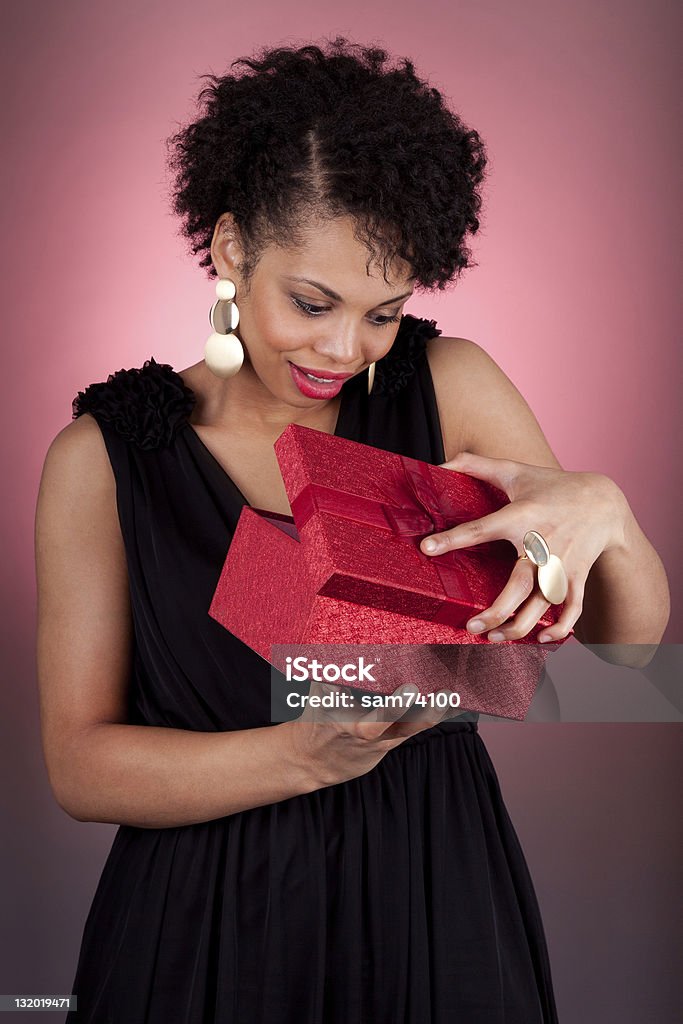 Młody African American kobieta otwarcia prezent - Zbiór zdjęć royalty-free (Otwierać)