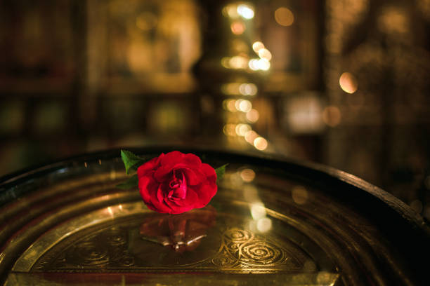 Horizontal view of a orthodox icon decorated with red flowers in an old Orthodox church