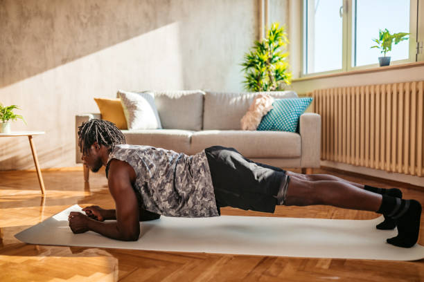 istock Man doing plank in his living room 1320198754