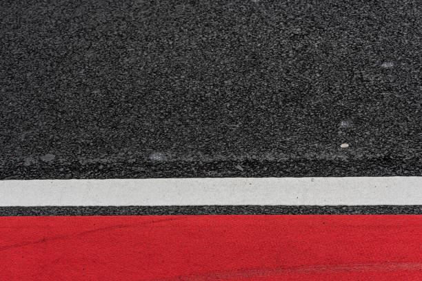 istock Asphalt decorated with a white line and a red field.. 1320198949