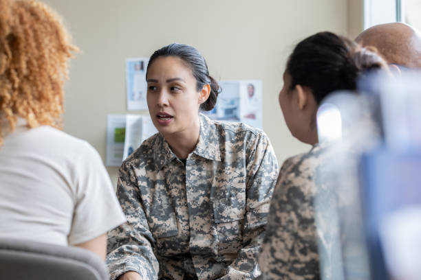 Adult military woman speaking during group therapy session Adult military woman speaking during group therapy session post traumatic stress disorder photos stock pictures, royalty-free photos & images