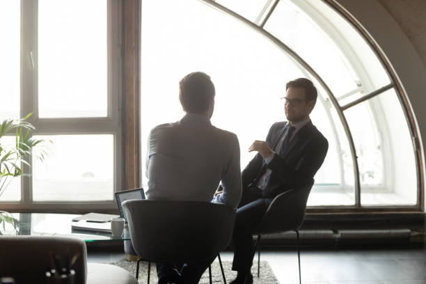 istock Rear view two businessmen discussing deal in modern office 1320207966