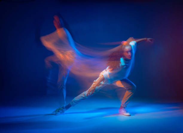 istock Mixed race female dancing in colorful neon light. Studio photo with long exposure. Expressive contemporary hip hop dance 1320208436