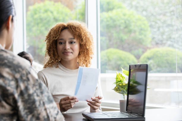 istock Young woman talks with military recruiter in office 1320208595