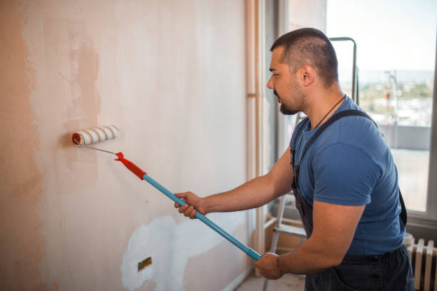 istock Hardworking painter painting the walls with paint roller 1320209155