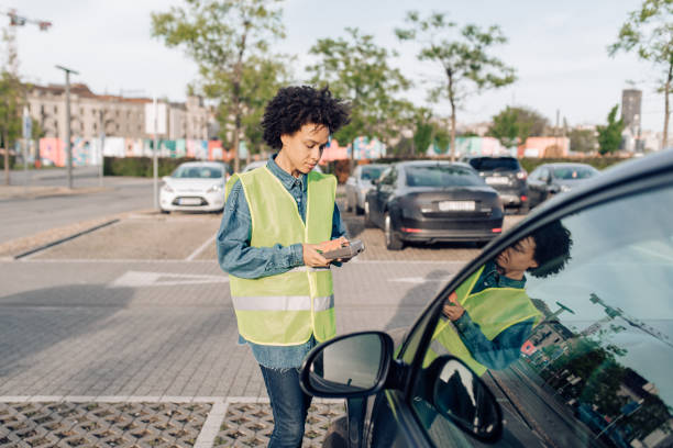 mujer trabajando como controladora de estacionamiento - pay as you go fotografías e imágenes de stock