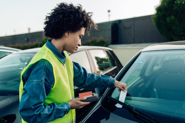 mujer trabajando en el estacionamiento como controladora de estacionamiento - pay as you go fotografías e imágenes de stock