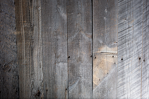 A view of a background of rustic reclaimed wood panels with dramatic lighting.