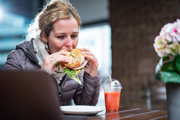 istock Young woman eating sandwich 1320213267