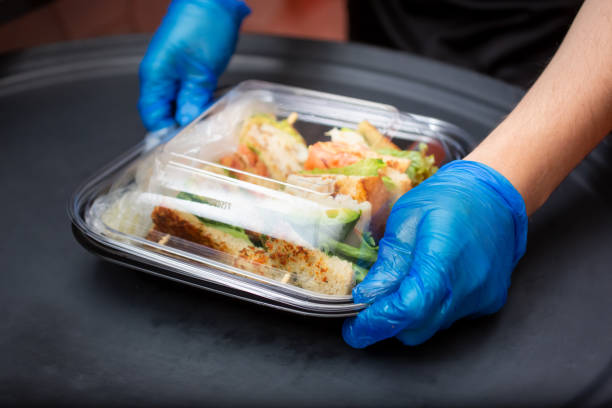 istock gloves on to-go food container 1320213910
