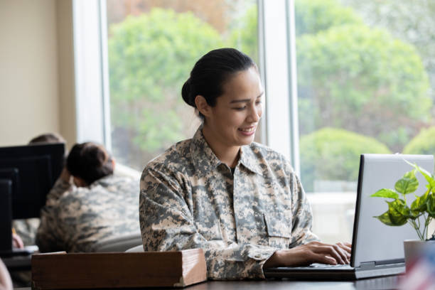 istock Mature female soldier sends emails while sitting in military office space 1320214066