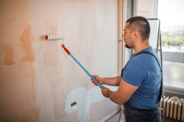 istock Confident painter painting the walls with paint roller 1320215623