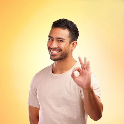 Man shows thumb-up gesture cheering up on gray