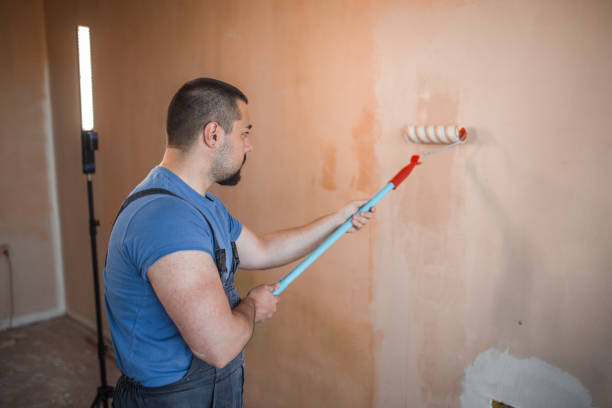 istock Punctilious worker painting the walls with paint roller 1320217535