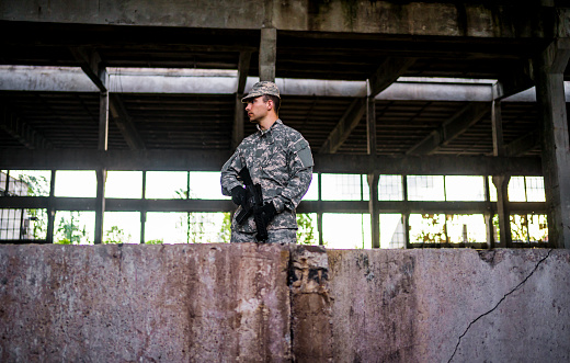 Armed soldier on a mission in a ruined building