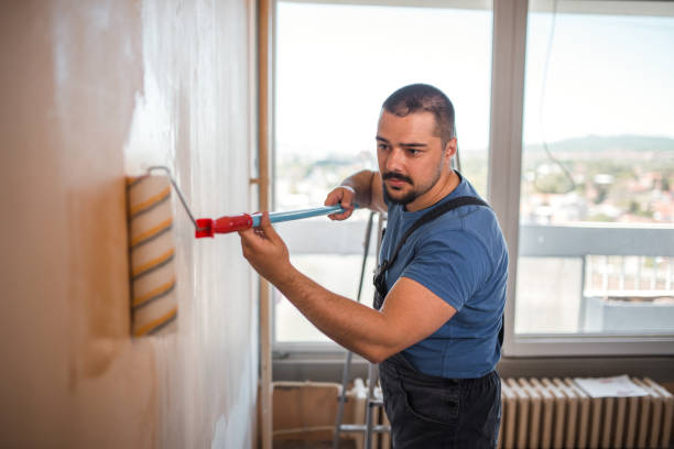 istock Concentrated painter painting the walls with paint roller 1320220032