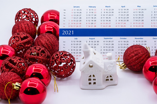 Toy house and calendar 2021. Red Christmas balls and house. Calendar 2021 and Christmas balls.