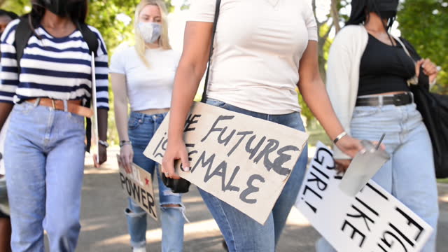 Group of teenagers walking with signs during a women's right march