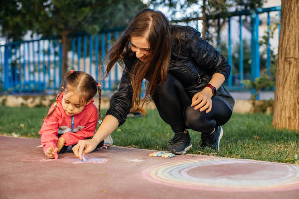 istock Little Girl Drawing with Sidewalk Chalk 1320226736