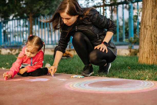 istock Little Girl Drawing with Sidewalk Chalk 1320227325