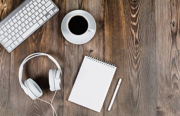 istock Keyboard, headphones, notepad and white color handle on a desktop table, a cup of coffee. Concept - online training, education, remote operation, webinars, seminars, home furnishings 1320227465