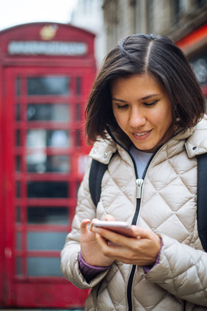linda mujer en londres usando smartphone - london england business telephone booth commuter fotografías e imágenes de stock