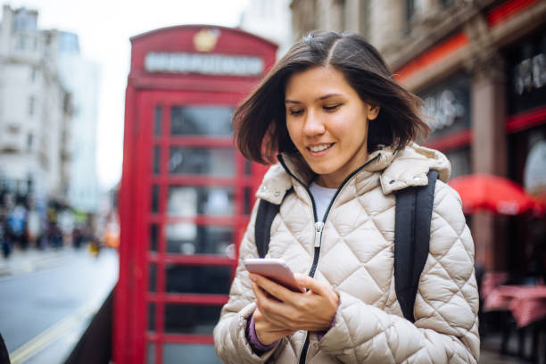 linda mujer en londres usando smartphone - london england business telephone booth commuter fotografías e imágenes de stock