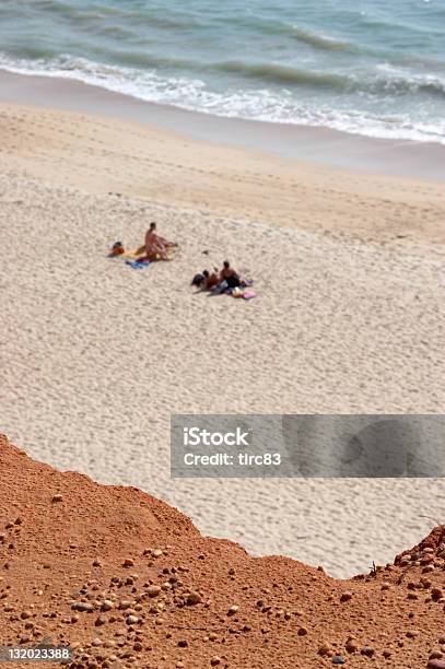 Photo libre de droit de Les Amateurs De Soleil Sur La Plage Déserte banque d'images et plus d'images libres de droit de Algarve - Algarve, Bain de soleil, Bleu