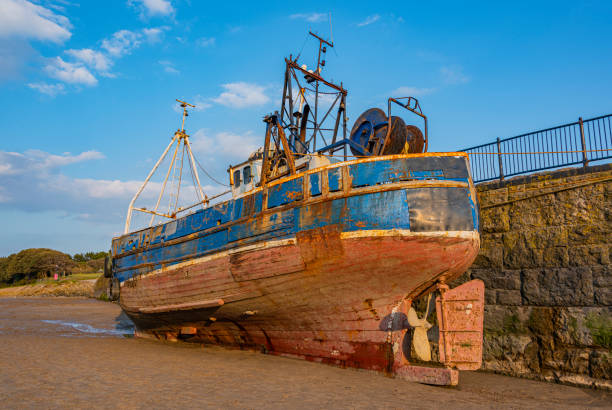 An abandoned cape islander fishing boat near a small fishing village.
