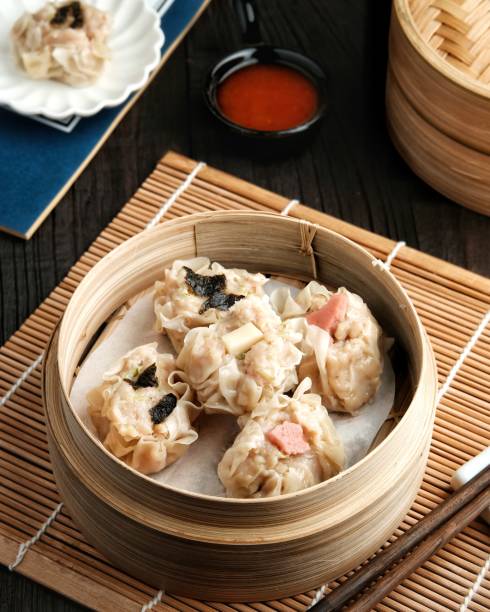 istock Dimsum with various toppings, served in a bamboo steamer and spicy sauce 1320253981
