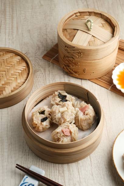istock Dimsum with various toppings, served in a bamboo steamer and spicy sauce 1320253985