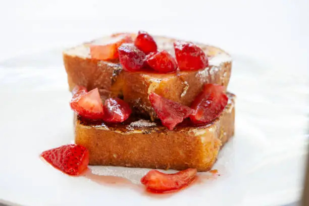 beautifully styled food photography with yummy french toast drizzled with fresh strawberries and powdered sugar, shot close up