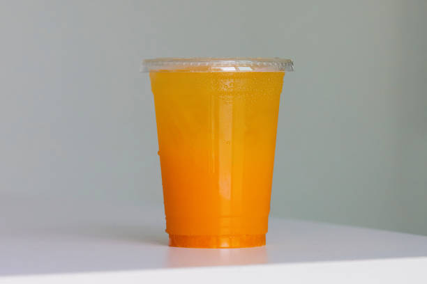 disposable plastic cup drinks , plastic cup of tea for takeaway place on white table. close up and selective focus - cocktail orange cup juice imagens e fotografias de stock