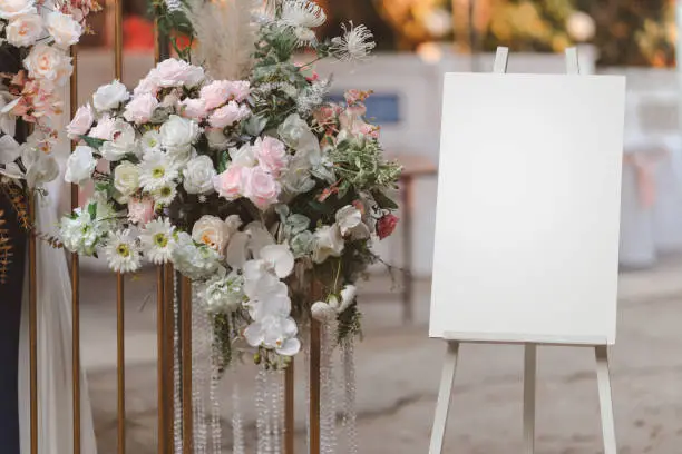 Photo of Empty white photo display board on stand for wedding arch.